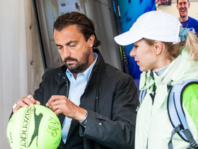 Henr iLeconte autographing a giant tennis ball
